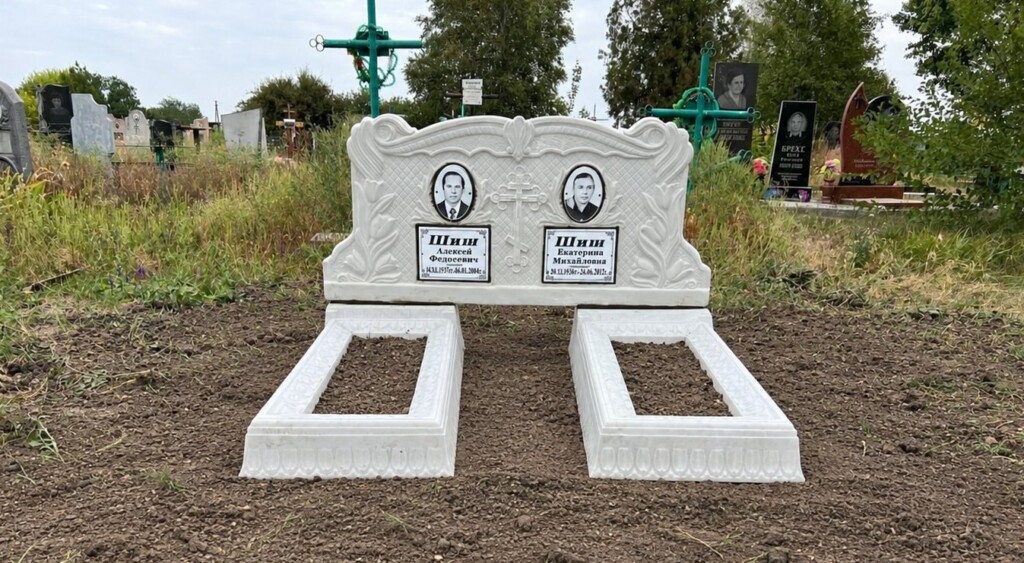Подвійний бетонний пам'ятник із двома портретами та аркою над двома могилами — Дніпро
